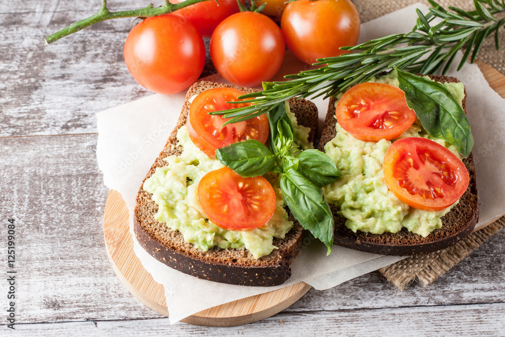 Avocado toast, cherry tomato on wooden background. Breakfast with toast avocado, vegetarian food, healthy diet concept. Avocado toast, cherry tomato on wooden background. Breakfast with toast avocado, vegetarian food, healthy diet concept.