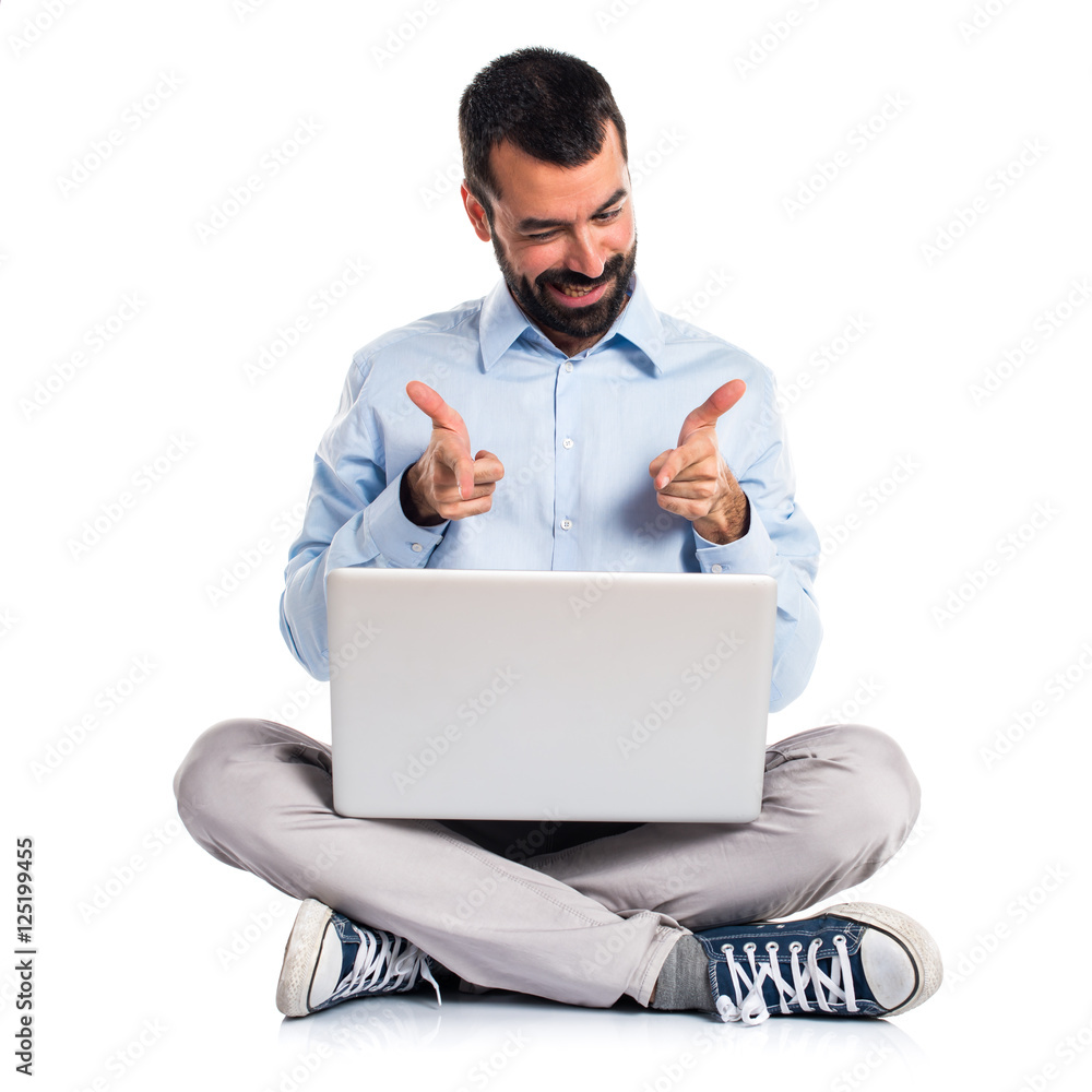 Man with laptop pointing to the front Man with laptop pointing to the front