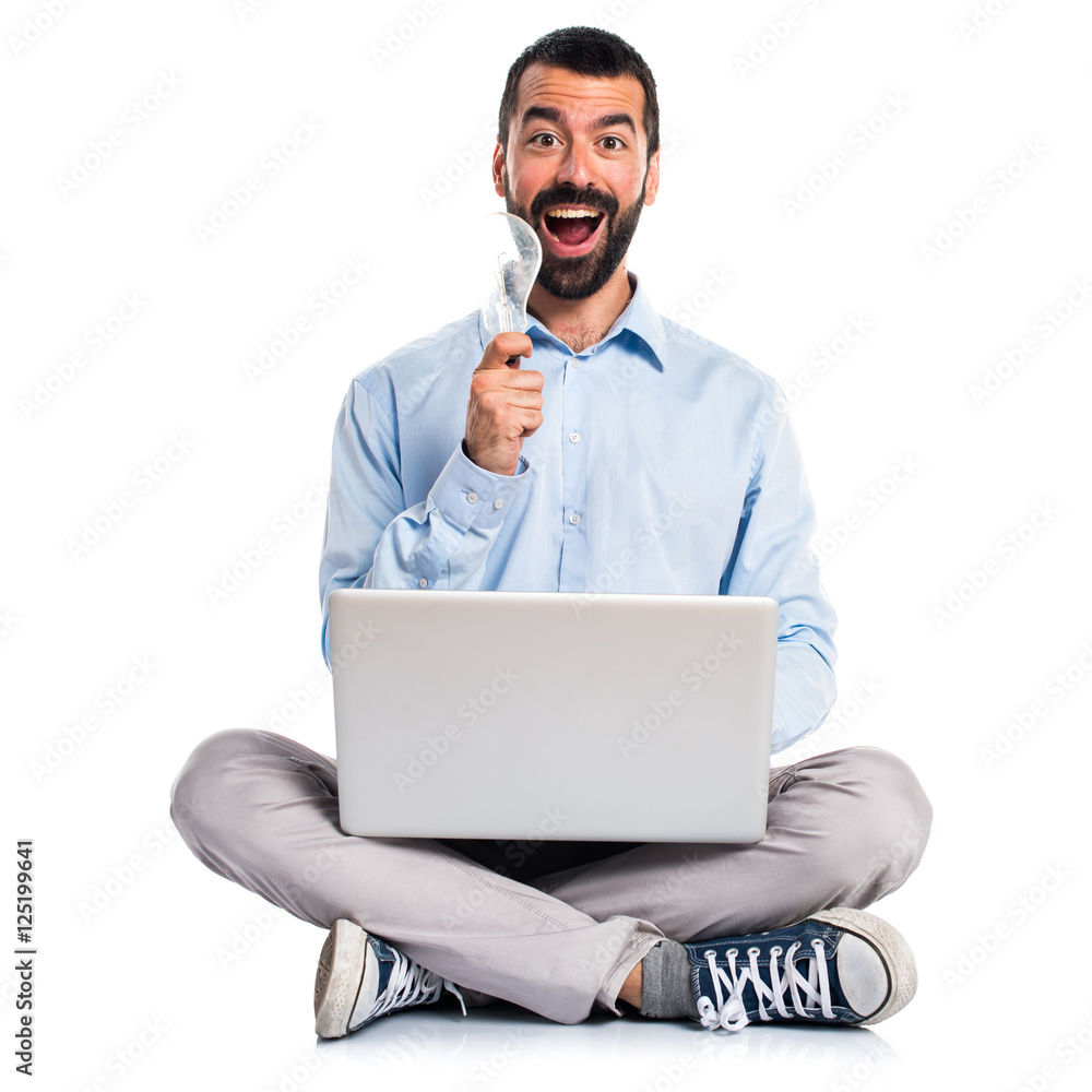 Man with laptop holding a bulb Man with laptop holding a bulb