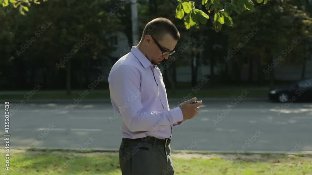 A young businessman in glasses making a phone call. A young businessman in glasses making a phone call.