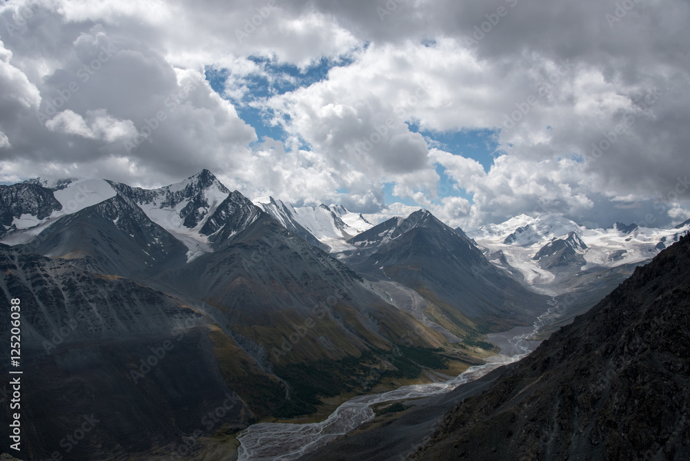 Wildlife Altai. The river, mountains and sky with clouds in summ Wildlife Altai. The river, mountains and sky with clouds in summ