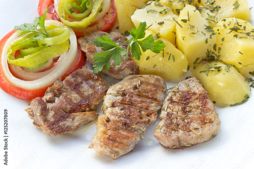 Grilled pork fillet meat and vegetables on plate