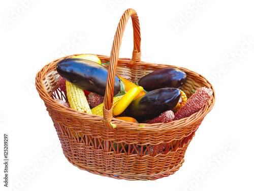 Yellow corn and eggplant vegetable in wicked basket isolated