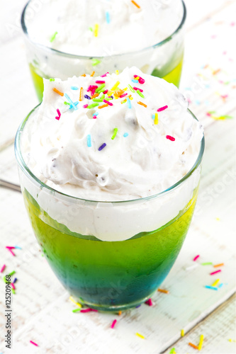 Colorful jelly with whipped cream and candy topping