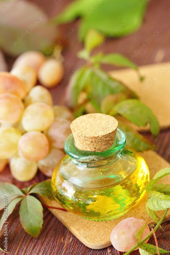 Bottle with grape seed oil on a wooden table Bottle with grape seed oil on a wooden table