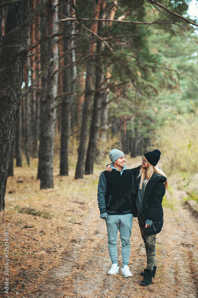 Portrait of young couple in love walking in beautiful forest enjoying hugging and smiling. Feelings, togetherness,friendship, love Portrait of young couple in love walking in beautiful forest enjoying hugging and smiling. Feelings, togetherness,friendship, love