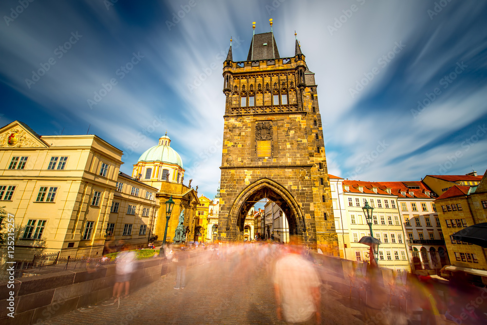 View on the tower of Charles bridge in the old town of Prague city. Long exposure image technic with blurred people and clouds