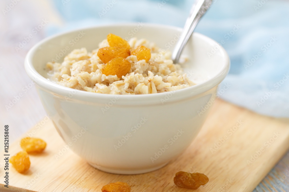 Porridge with raisin and honey in white bowl for breakfast Porridge with raisin and honey in white bowl for breakfast