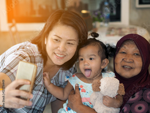 Thailand family taking photo with smart phone, Baby girl, Grandm photo