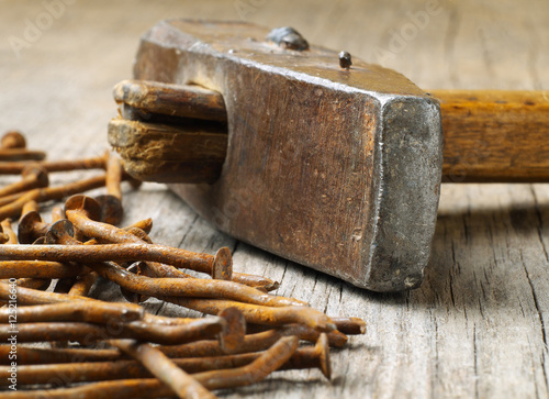 old used hammer on wooden board with rusty nails, macro, shallow depth of field