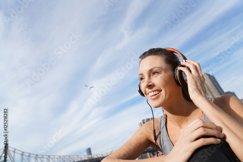 Closeup of jogger girl listening to music with headset