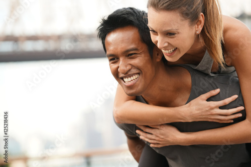 Man giving piggyback ride to girlfriend