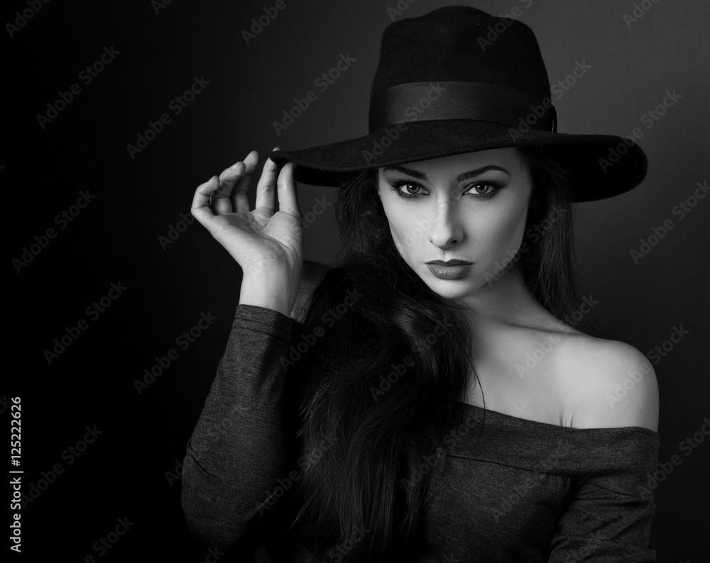 Elegant makeup woman in fashion hat posing on dark shadow backgr Elegant makeup woman in fashion hat posing on dark shadow backgr