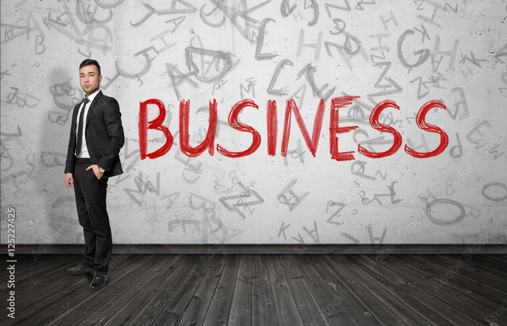 Businessman standing near red word 'Business'. Businessman standing near red word 'Business'.
