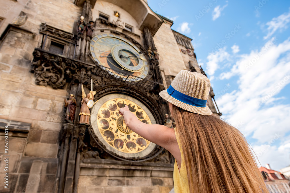 Obraz premium Female tourist pointing on the famous astronomical clock in Prague