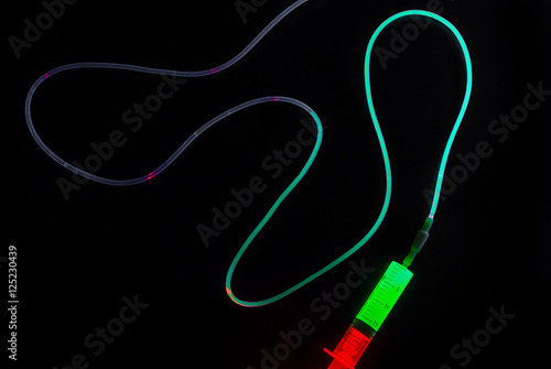 Syringe injecting a glowing liquid into the dropper