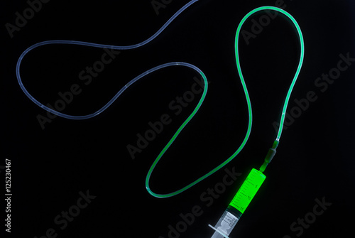 Syringe injecting a glowing liquid into the dropper