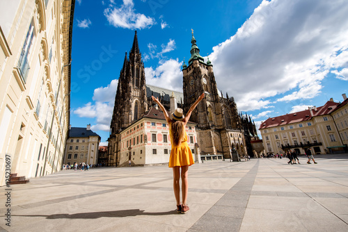 Fotografiet Young female tourist in front of the Vitus cathedral in the old town of Prague