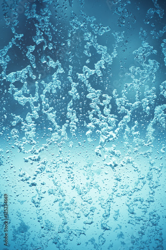 toned winter window with snow and water droplets