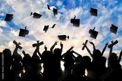 Students graduate cap throwing in sky photo