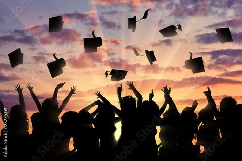 Graduates sunset throw graduate cap