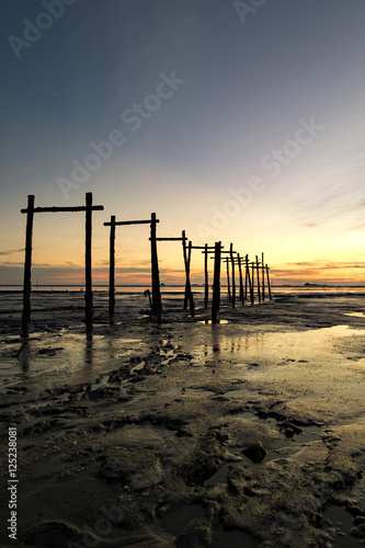 amazing tropical sunset background  wooden structure on the muddy beach