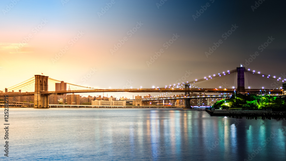 Composite image with Brooklyn Bridge transitioning from sunset to night on Pier2 park in New York City