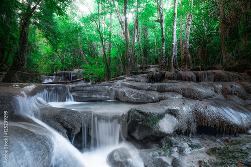 Fototapeta Naklejka Na Ścianę i Meble -  Jangle landscape with flowing turquoise water of Erawan cascade waterfall at deep tropical rain forest. National Park Kanchanaburi, Thailand