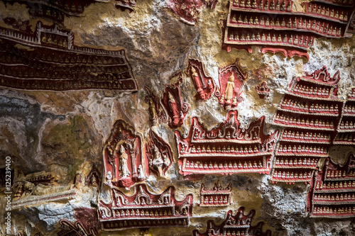 Amazing view of religious carving on limestone rock in sacred Buddhist Kaw Goon cave. Hpa-An, Myanmar (Burma) travel landscapes and destinations