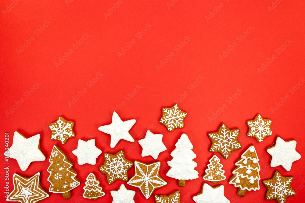 red background with homemade various shaped christmas gingerbread cookies