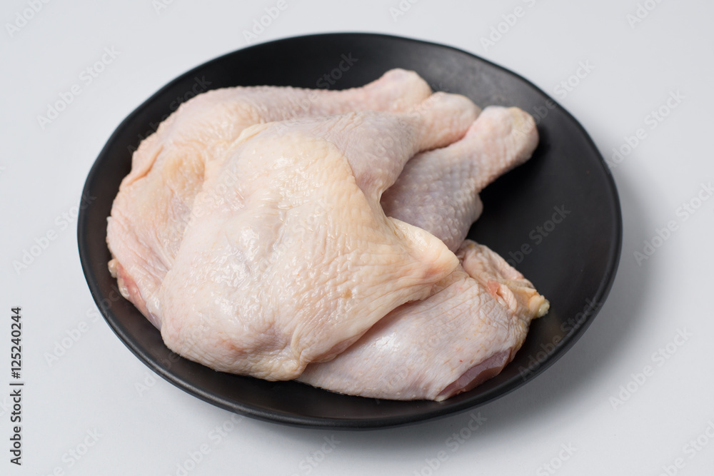 Fresh raw chicken legs on black dish Fresh raw chicken legs on black dish