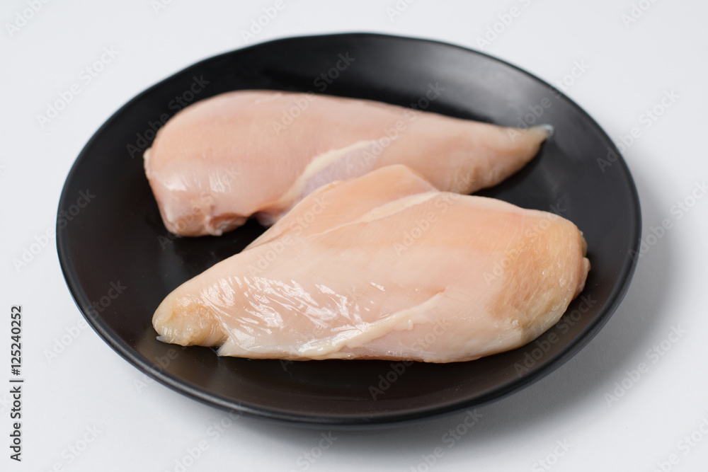 Fresh chicken breast fillets on black dish