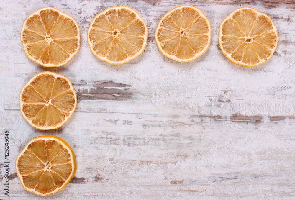 Slices of dried lemon on old wooden background, copy space for text Slices of dried lemon on old wooden background, copy space for text