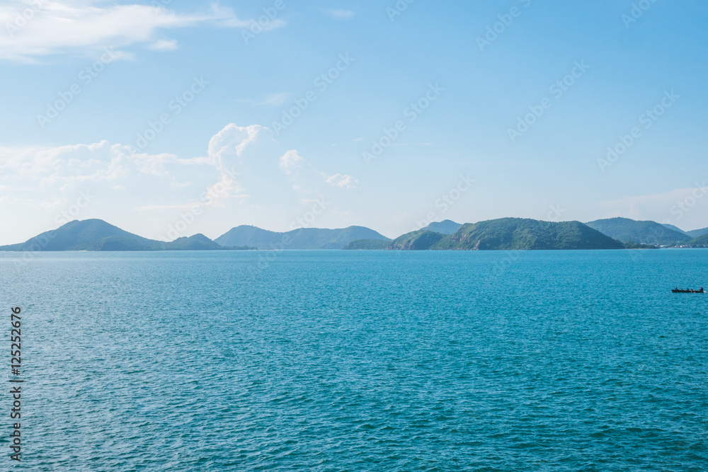 Blue sea in summer with an island is the back background in the afternoon