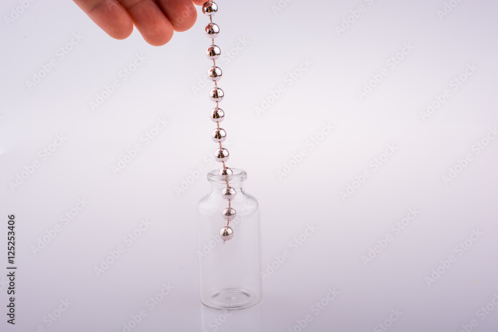 Little glass bottle with beads in hand Little glass bottle with beads in hand