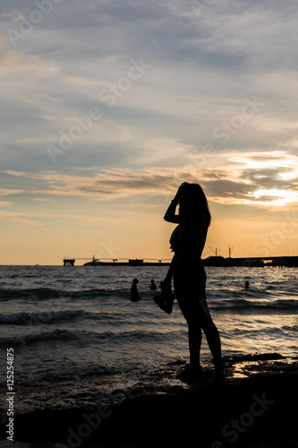 Silhouettes woman with seascape and twilight background photo
