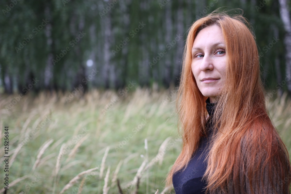 Attractive woman with red hair in the autumn forest Attractive woman with red hair in the autumn forest