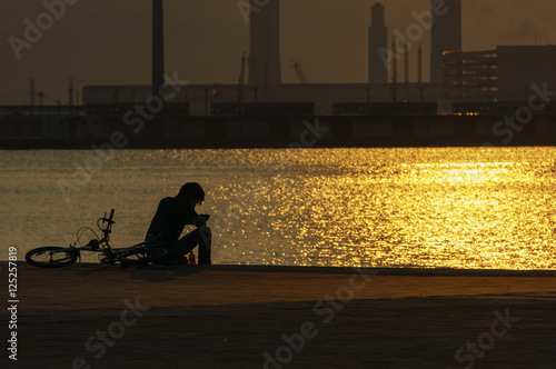 夕焼けの中 一人座る男性の後ろ姿 Stock Photo Adobe Stock 夕焼けの中 一人座る男性の後ろ姿 Stock Photo Adobe Stock