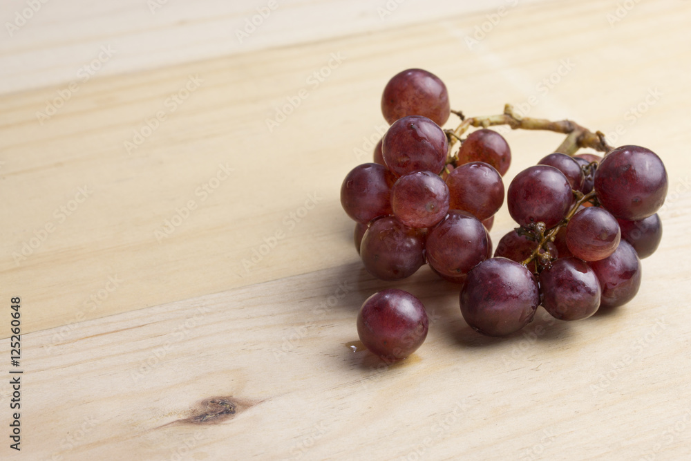 group of fresh red grape on wood table group of fresh red grape on wood table