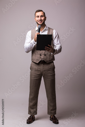 The Showman interviewer with blank. Young elegant man holding microphone against white background.Showman concept.