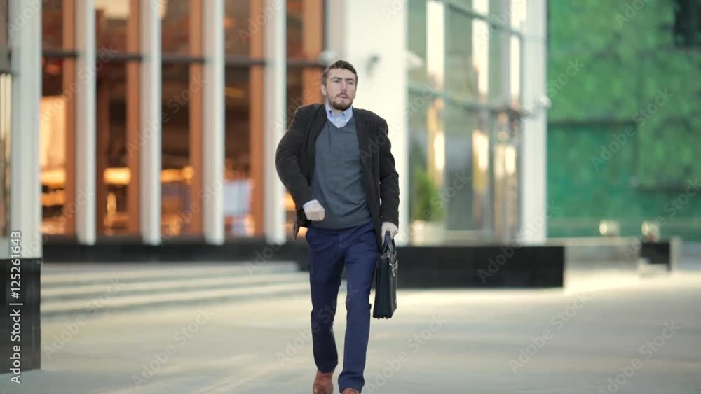 Attractive man with a beard and briefcase dancing in the street Attractive man with a beard and briefcase dancing in the street