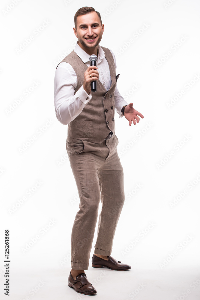 Young man in suit singing over the microphone with energy. Isolated on white background. Singer concept. Young man in suit singing over the microphone with energy. Isolated on white background. Singer concept.