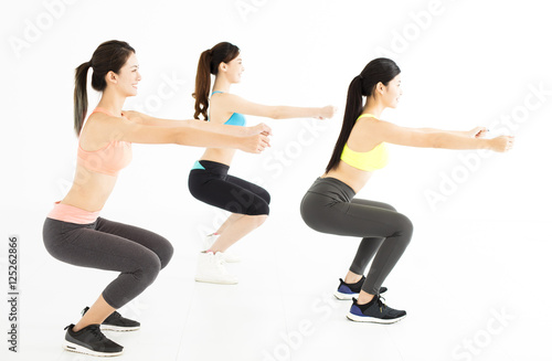 smiling young fit group stretching and squat