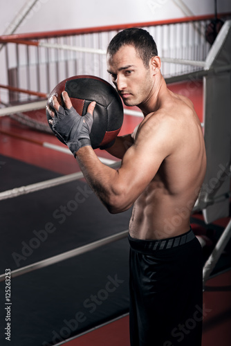 Muscular man holding fitness ball
