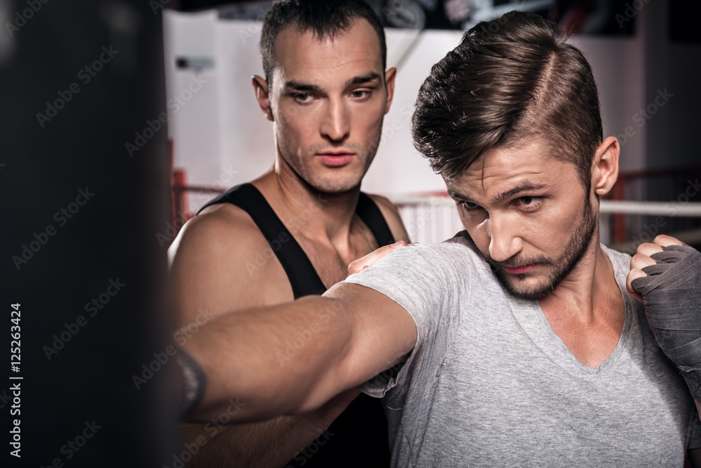 Fototapeta premium Close up of man training on punch bag