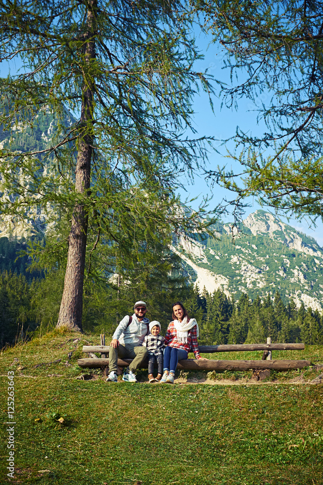 Fototapeta premium young family sitting on the bench