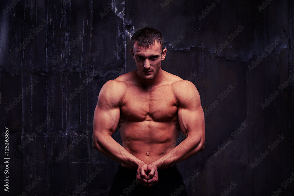 Fitness male model showing his athletic strong body