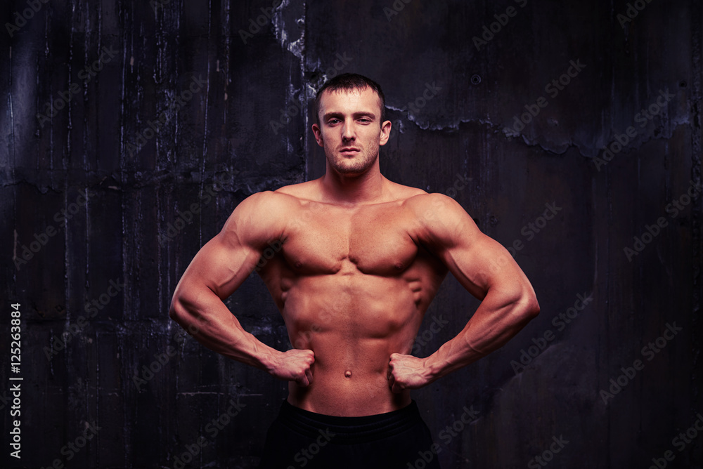 Handsome bodybuilder with toned muscular body posing shirtless