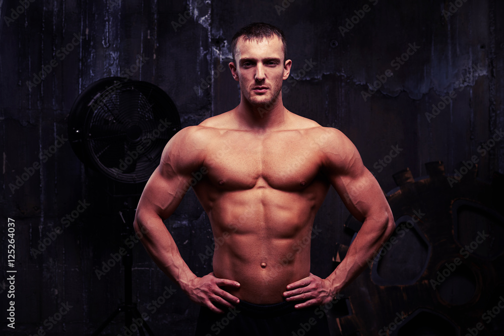 Muscular sexy shirtless man standing with hands on hips
