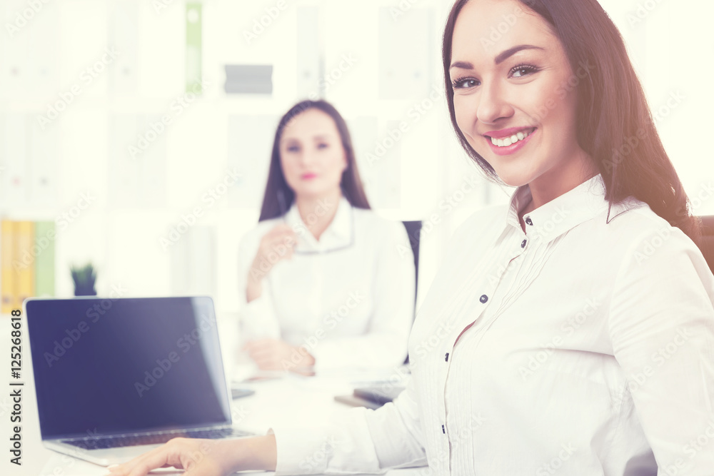 Smiling businesswoman in office with colleague Smiling businesswoman in office with colleague